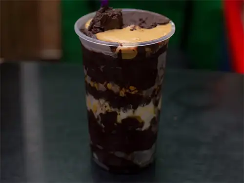 copo de açaí com pasta de amendoim e leite em pó sobre o balcão