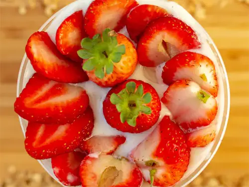 copo com creme de cupuaçu visto de cima com morangos